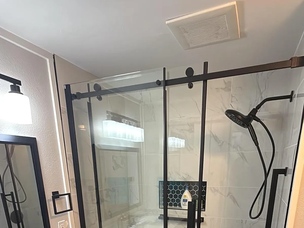 Finished bathroom with a glass walk-in shower, vanity and tile floor