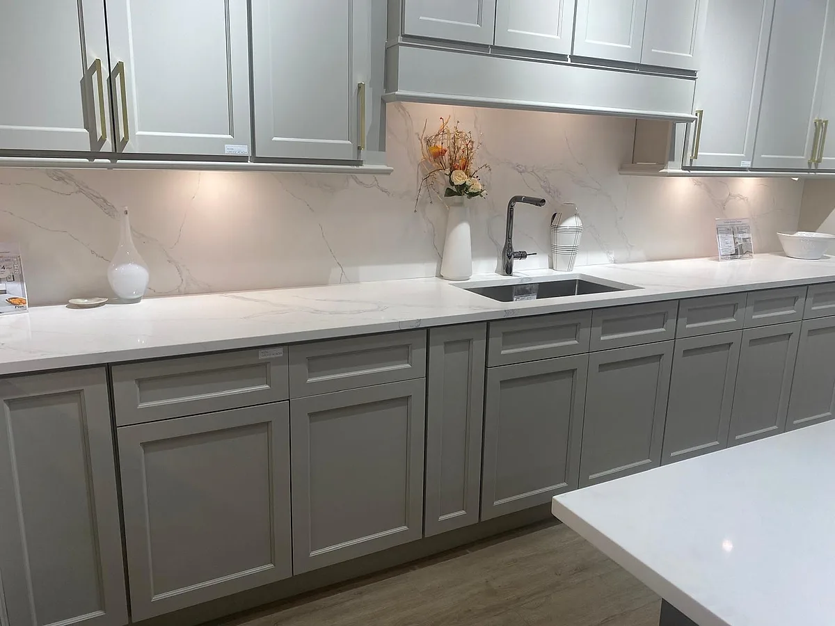 White quartz countertops and backsplash over gray cabinetry