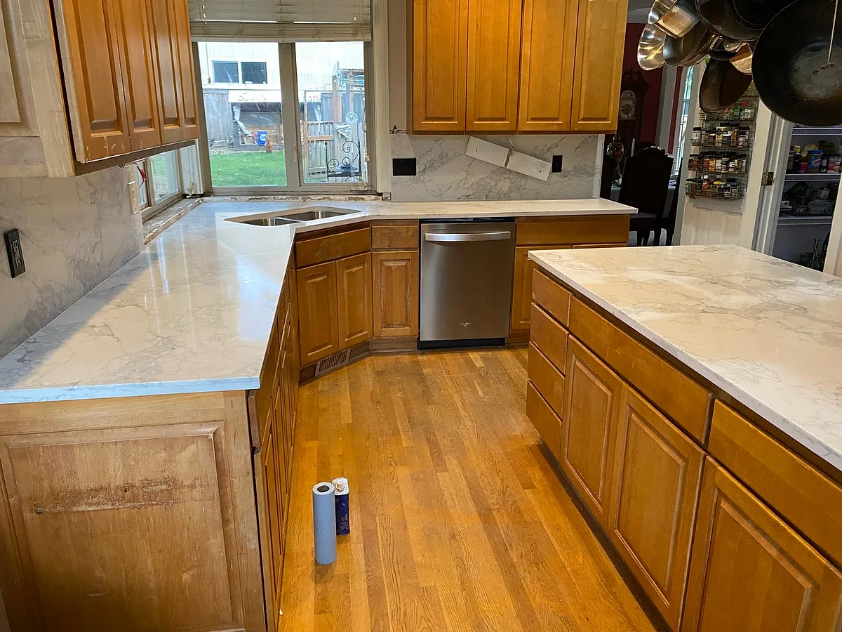 Granite countertops wrapping a wood-cabinet kitchen with a gas cooktop
